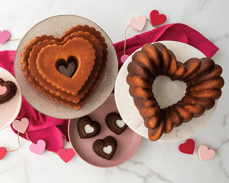 Two heart shaped bundt cakes next to each other with Valentine's decorations.